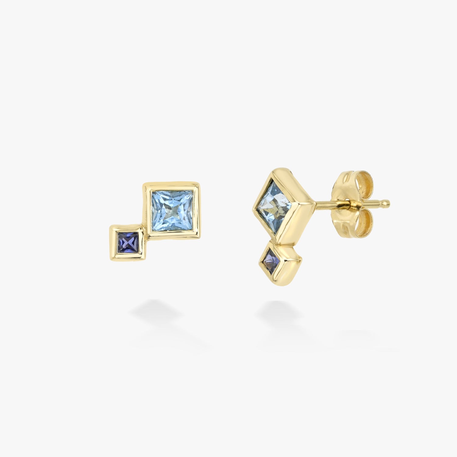 Gold earrings with blue sapphire and blue topaz on a white background
