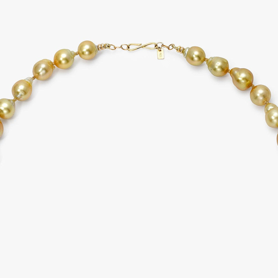 Gold pearl necklace on a white background